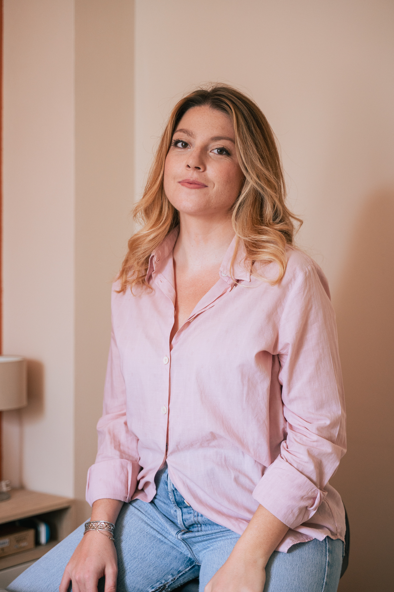 Chiara De Mattia Co founder di Natural Digital Creatives con camicia rosa e jeans nel suo ufficio dai toni soft